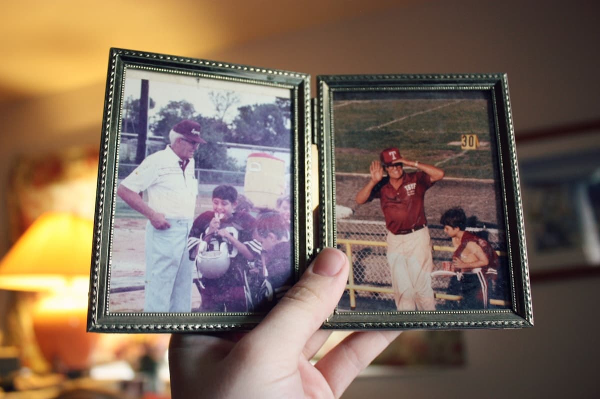 Hands holding a stack of old family photographs